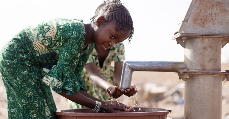 Africa Youngster with pure Water in a rural village